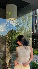 Musculosa color beige con cuello alto y diseño plisado.