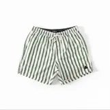 Short de baño estampado en tonos verde y beige, con cintura elástica ajustable con cordón, dos bolsillos laterales y uno trasero.