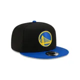 Gorro snapback New Era 9FIFTY con corona negra y visera azul. Presenta el logo de los Golden State Warriors bordado en el frente en amarillo y azul.