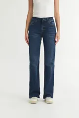 Jean de mezclilla azul oscuro, tiro alto, con corte acampanado (estilo Oxford o bootcut) y roturas sutiles en los muslos.