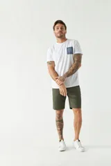 Bermuda color beige, de corte chino clásico, con bolsillos laterales y traseros, cierre con botón y cremallera, presillas para cinturón y logo bordado. Confeccionada en algodón y spandex.