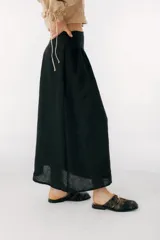 Falda midi negra de lino italiano, de corte evasé y cintura alta.