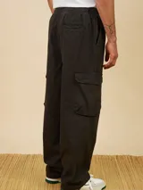 Pantalón cargo azul petróleo de corte holgado, con cintura elástica ajustable con cordón y bolsillos laterales con solapa.