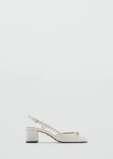 Zapato blanco de cuero sintético con tacón bloque, punta cuadrada, cierre con hebilla y detalle de eslabones dorados.