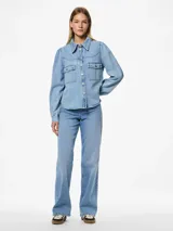 Camisa de denim celeste de algodón, de corte regular, con cuello clásico, mangas largas con puños abotonados, bolsillos con solapa abotonada en el pecho y cierre frontal con botones.