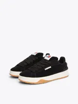 Zapatillas urbanas Tommy Jeans de corte bajo, color negro, confeccionadas en ante con interior de poliéster, entresuela texturizada color crema y suela de goma color caramelo. Presentan logo de la marca en el lateral y en la lengüeta.