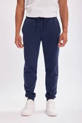 Pantalón deportivo tipo jogging azul marino, con cintura elástica y cordón ajustable.