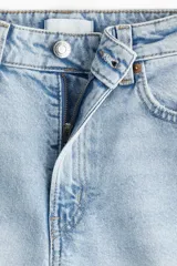 Pantalón de jean celeste de corte ancho, tiro alto y largo tobillero.