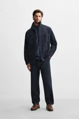 Pantalón azul marino de corte recto, confeccionado en tejido de algodón y lino. Tiene cintura elástica ajustable con cordón, bolsillos delanteros y traseros de vivo. Cierre frontal con cremallera y botón.