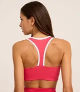 Top deportivo rosado de microfibra con escote nadador, copa desmontable, estampado frontal con la frase "athletics new york city" y vivos blancos en escote y sisas.