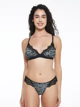 Conjunto de ropa interior color blanco con estampado de manchas rosadas y detalles de encaje blanco. Incluye corpiño triangular sin aro y tanga con laterales de encaje.