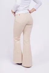 Pantalón Oxford color beige con corte ajustado en la parte superior y acampanado con aberturas en el ruedo.