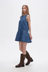 Vestido corto de denim azul, sin mangas, con cuello redondo y falda con volados.