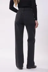 Pantalón de jean negro de corte recto, con detalle de ojalillos metálicos plateados en ambas piernas.