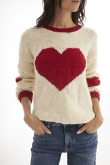 Sweater de lana merino color crema con un corazón rojo en el centro, cuello y puños acanalados en rojo.
