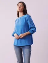 Blusa blanca texturada marca Ruby Rd, con escote redondo y mangas 3/4 con puño elastizado y apliques de broderie. Confeccionada en poliéster y elastano.