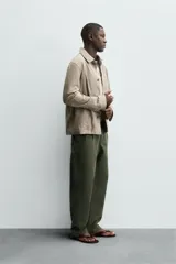 Cazadora de hombre de corte regular fit, confeccionada en piel con acabado ante color beige claro. Presenta cuello solapa, manga larga con puño de botón, bolsillos de plastrón en la cadera y cierre frontal con botonadura.