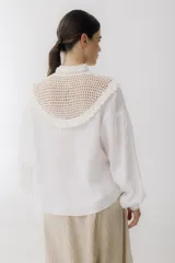 Blusa color ladrillo con cuello alto de crochet y lazos para ajustar. Mangas largas abullonadas con puños elásticos.