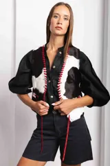 Chaleco con estampado de vaca en tonos marrones y blancos, con detalles de pasamanería en cuero.