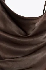 Vestido corto marrón de tejido satinado, con escote fluido y tirantes finos.