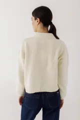 Cardigan corto color beige, tejido en 100% lambswool, con detalle bordado en el pecho.