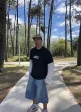 Remera negra de algodón de corte oversize con estampado en la espalda con un logo de reciclaje y la frase "XTREME WEAR BREAKING RULES".