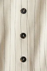 Vestido corto de breteles color crudo con rayas verticales negras, escote cuadrado, botonadura frontal y bolsillos insertados decorativos.