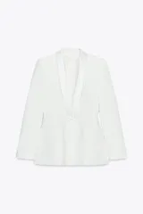 Blazer blanca entallada con cuello solapa combinado, manga larga con hombreras, bolsillos de plastrón en delantero, costuras marcadas, forro interior a tono y cierre frontal con botón forrado.