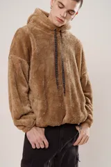 Hoodie beige de piel de corderito sintético, corte oversize con cierre central al estilo anorak, capucha con cordón ajustable y bolsillo canguro.