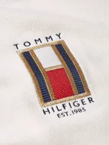 Sweater de punto color crema, con cuello redondo y logo bordado en el pecho.