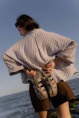 Sandalias tipo mule de cuero color marrón chocolate, con diseño de tiras anchas cruzadas y suela plana.