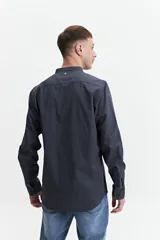 Camisa azul de manga larga con cuello mao y cartera abotonada.