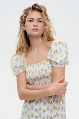 Vestido largo de algodón con estampado floral, escote cuadrado, cuerpo fruncido, mangas cortas abullonadas y falda con leve vuelo.