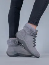 Bota de mujer en color gris con detalles de pelaje en el tobillo y suela gruesa.