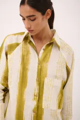 Camisa tipo vestido con cuello camisero, manga larga y estampado a rayas verticales en tonos verde y blanco.