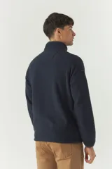 Campera polar azul marino de poliéster con cuello alto, cierre frontal, bolsillos laterales y logo estampado en el pecho.