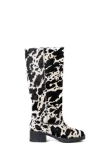 Bota de cuero con estampado animal print de vaca, caña alta y taco bajo.