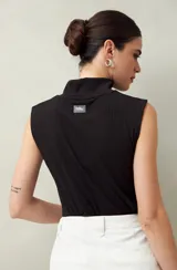 Top negro sin mangas de cuello alto tipo polera.