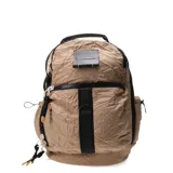 Mochila beige con textura arrugada, cierre superior con cremallera, bolsillo frontal con cremallera, asa de mano superior y correas de hombro ajustables.