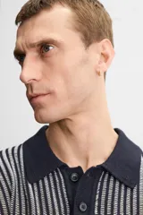 Polo de punto de algodón a rayas verticales en tonos azul marino y gris. Tiene cuello clásico, tapeta con botones y corte recto.