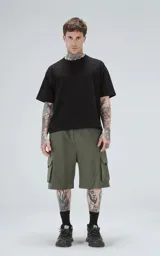 Bermuda de algodón rústico color verde militar, de calce oversize, con cintura elástica y bolsillos cargo con cierre en los laterales.