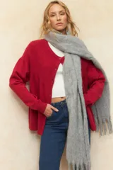 Cardigan corto rojo de tejido tramado, con cuello redondo, manga larga y botones grandes a tono.