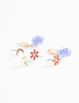Set de tres pares de aros plateados: un par de aros tipo botón con forma de media luna, un par de aros tipo botón con forma de flor y cristales verdes, y un par de aros colgantes con forma de racimo de uvas rojas.