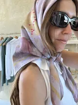 Pañuelo de seda cuadrado con estampado abstracto en tonos lila, violeta y dorado.