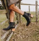 Bota corta de cuero vacuno color negro, con elástico lateral, taco de madera y punta fina.