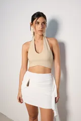 Top corto azul con brillos, escote halter y espalda descubierta.