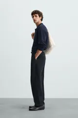 Polo de manga larga color negro, tejido en hilatura con mezcla de algodón y seda, de corte regular fit, con cuello solapa y cierre frontal de botonadura.