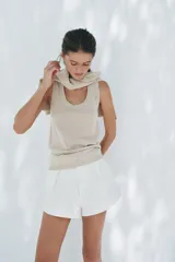 Top color crema de punto liso con escote redondo y sisa.