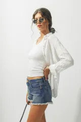 Camisa blanca de lino de manga larga con cuello clásico y cierre frontal con botones.