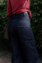 Jean wide leg color marrón, con corte recto y amplio, y costuras protagonistas que crean un diseño geométrico en las piernas.